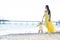 Happy family in a yellow dress. Mother and child are walking on the beach