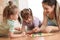 Happy family. Young mother playing ludo boardgame with her daughters while spending time together at home.