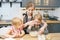 Happy family young mother and two little daughters preparing dough for pancakes or cookies together in the kitchen