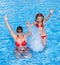 Happy familyl learn child swim in swimming pool.