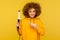 Happy fancy hipster woman with perfect afro hairdo showing iron curler, professional curling tong