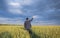 Happy farmer, businessman, standing in wheat field