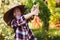 Happy farmer child girl picking fresh home growth carrot harvest from own garden