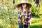 Happy farmer child girl picking fresh home growth carrot harvest from own garden