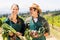 Happy farmer couple holding leafy vegetables