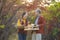 Happy farmer family carrying produce harvest with homegrown organics apple, squash and pumpkin with fall color from maple tree