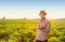 Happy farmer holding potatoes in front of field landscape