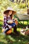 Happy farmer kid girl picking autumn vegetable harvest in the garden