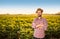 Happy farmer standing in front of potatoes field landscape