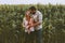 Happy farmers family parents with infant baby outdoor