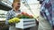 Happy farmers looking at fresh flowers in box and smiling, greenhouse business