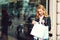 Happy fashionable woman with shopping bags standing at shop window. Lifestyle concept. Positive emotions. Girl enjoying purchases