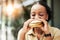 Happy, fast food and black woman eating a sandwich in an outdoor restaurant as a lunch meal craving deal. Breakfast