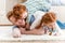 Happy father with adorable redhead children playing and having fun together on floor