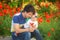 Happy father and child playing together on the poppy meadow.