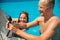 Happy father and daughter having fun in swimming pool, taking photos and videos with waterproof action camera. family on vacation.