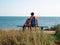 Happy father and daughter sitting on bench with marine landscape view. Dad and child having fun walking together