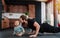 Happy father doing push upps next to his infant baby, moved and amused by him