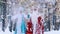 Happy Father Frost and laughing Snow Maiden in snowy forest