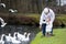 Happy father and his toddler daughter feeding geese