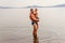 Happy father hugs his little son while standing in the lake