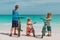 Happy father with kids biking on beach