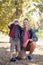 Happy father kneeling by boy looking through binoculars