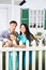 Happy father, mother and little daughter stand next to fence