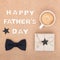 Happy Father`s Day Background. Cup of coffee, beautiful present and black bow tie on brown background flat lay. Fathers day.