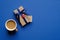 Happy Father`s day concept. Flat lay composition with vintage gift box wrapped blue ribbon and cup of coffee on blue background.