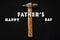 Happy father`s day text sign on working tools hammer on black ru