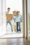 Happy father and son with cardboard boxes entering into new house