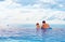 Happy father and son enjoy beautiful seascape from infinity pool, vacation concept