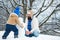 Happy father and son making snowman in the snow. Handmade funny snowman. Happy family plaing with a snowman on a snowy