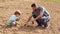 Happy father and son planting on spring field. Garden tools. Eco living - father and son farmer planting in the farm