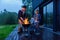 Happy father and son preparing a barbecue on a family vacation on the terrace of their modern house in the evening.