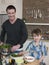 Happy Father And Son Preparing Salad At Kitchen Counter