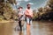 Happy father and son together fishing in summer day under beautiful sky on the river. Fisherman and trophy trout. Still