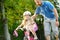 Happy father teaching his little daughter to ride a bicycle. Child learning to ride a bike.