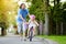 Happy father teaching his little daughter to ride a bicycle. Child learning to ride a bike.