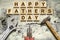 Happy Fathers Day inscription on wooden cubes with working tools on an old vintage concrete wall. Happy Father`s Day Concept. Gre