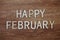 Happy February text message on wooden background