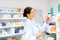 Happy female apothecary with drug at pharmacy