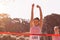 Happy female athlete with arms raised crossing finish line