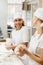 happy female bakers kneading dough together