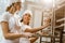 happy female bakers putting fresh pastry on shelves