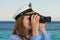 Happy female captain looks through a binoculars