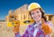 Happy Female Construction Worker with Thumbs Up Holding Level Wearing