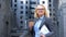 Happy female corporate worker holding coffee cup and work documents, career