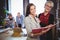 Happy female coworkers standing with file in creative office